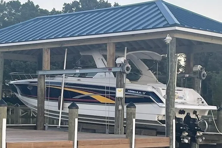 Slide: The Image of 2006 Formula 330 Sun Sport boat docked under a blue-roofed shelter. - 6