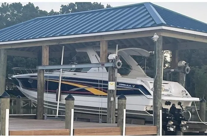 Slide: The Image of 2006 Formula 330 Sun Sport boat docked under a blue-roofed shelter. - 8
