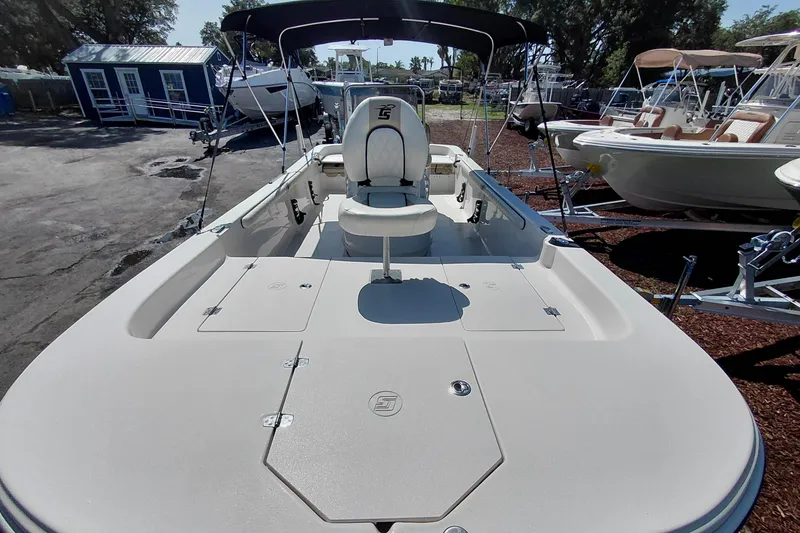 Slide: The Image of 2021 Carolina Skiff 21 LS boat with seating and canopy, displayed outdoors. - 10