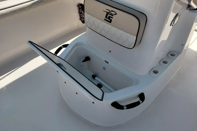 Slide: The Image of 2021 Carolina Skiff 21 LS boat interior with open storage compartment and rod holders. - 18