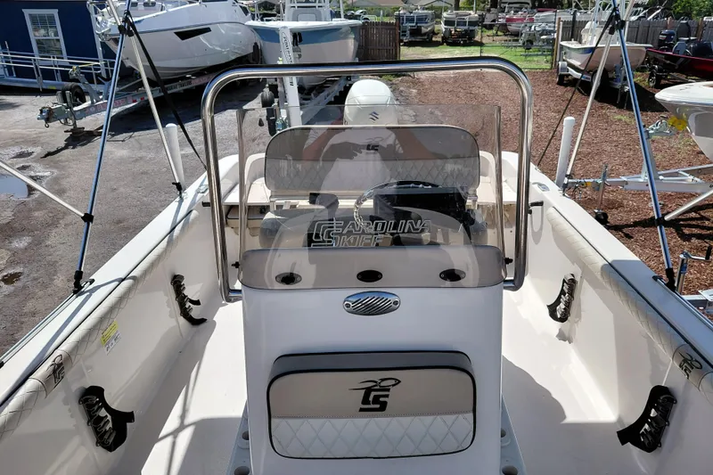 Slide: The Image of 2021 Carolina Skiff 21 LS boat interior with steering console and seating in a marina. - 19