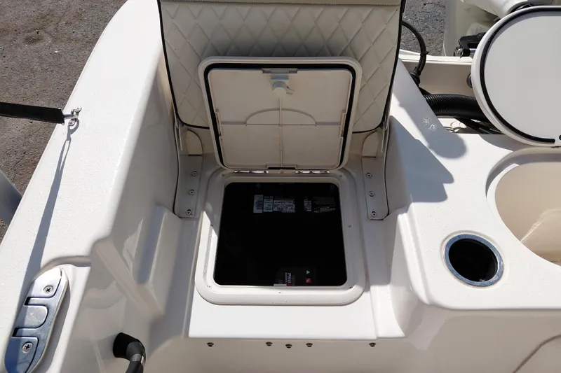 Slide: The Image of 2021 Carolina Skiff 21 LS boat storage compartment with open hatch and cup holder. - 31