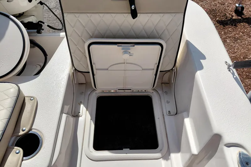 Slide: The Image of 2021 Carolina Skiff 21 LS boat storage compartment with open hatch and cushioned seating. - 32