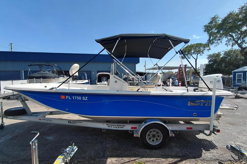 Slide: The Image of 2021 Carolina Skiff 21 LS boat with canopy on trailer, parked outdoors. - 4