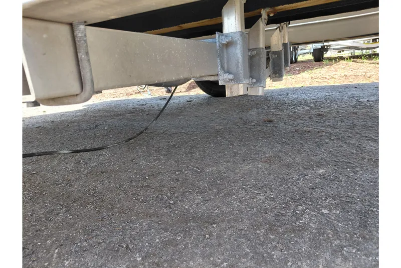 Slide: The Image of Underside view of a 2021 Carolina Skiff 21 LS trailer on pavement. - 42