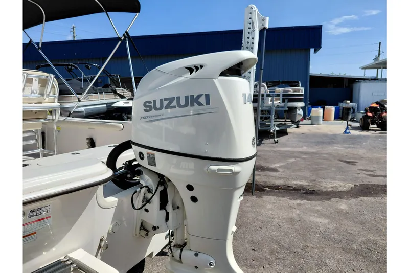 Slide: The Image of 2021 Carolina Skiff 21 LS with Suzuki 140 outboard motor in a boatyard setting. - 43