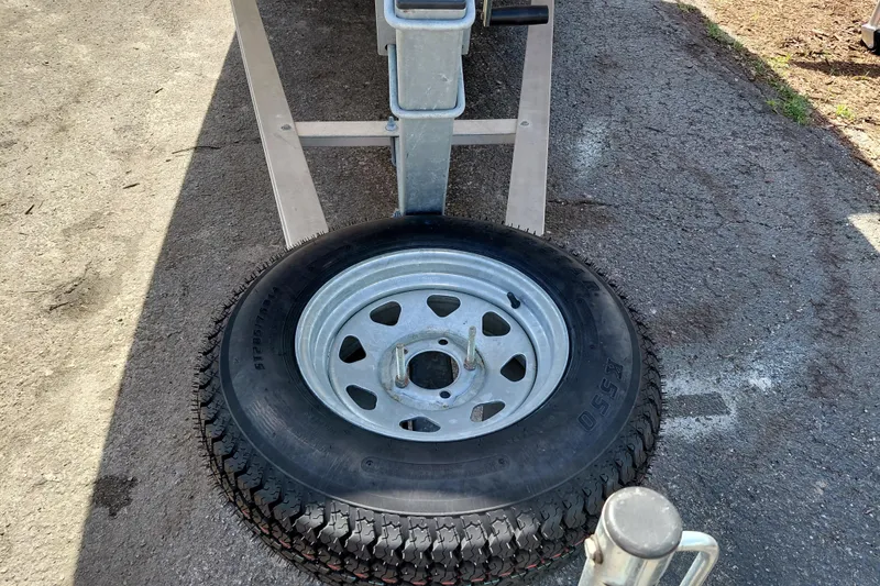 Slide: The Image of Trailer tire attached to a 2021 Carolina Skiff 21 LS boat trailer on asphalt. - 9