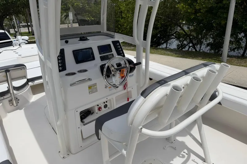 Slide: The Image of 2015 Robalo 246 Cayman boat console with steering wheel and rod holders. - 14