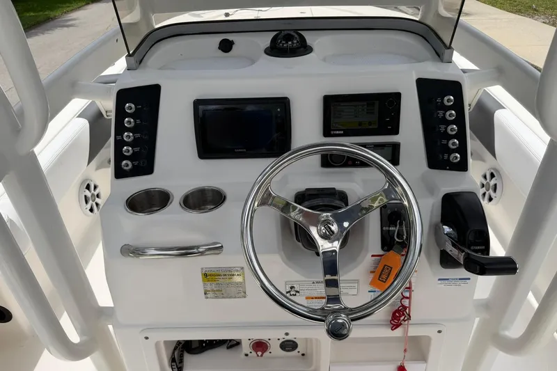 Slide: The Image of 2015 Robalo 246 Cayman boat dashboard with steering wheel and control panel. - 16