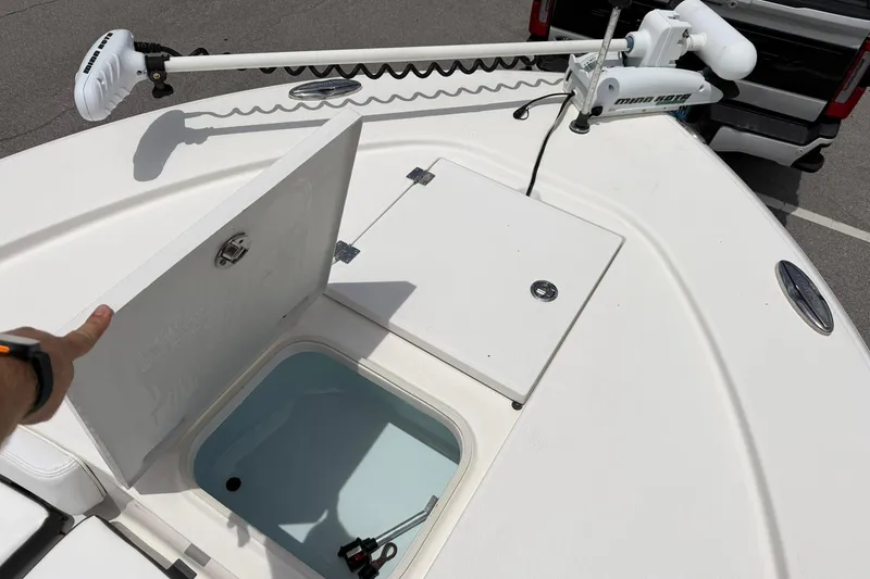 Slide: The Image of 2015 Robalo 246 Cayman boat deck with open storage compartment and trolling motor. - 21