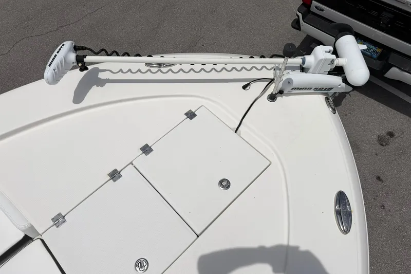 Slide: The Image of 2015 Robalo 246 Cayman boat deck with trolling motor, parked on pavement. - 22