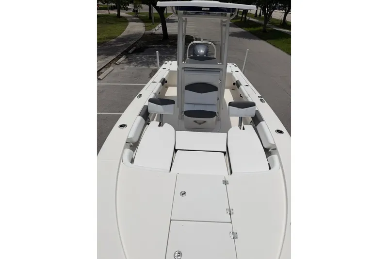 Slide: The Image of 2015 Robalo 246 Cayman boat interior with seating and console, parked outdoors. - 23