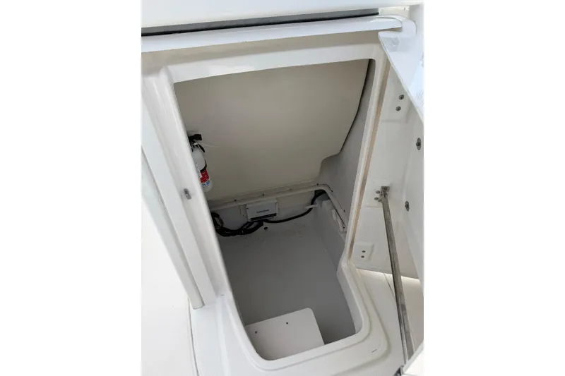 Slide: The Image of Storage compartment inside a 2015 Robalo 246 Cayman boat, featuring a fire extinguisher. - 25