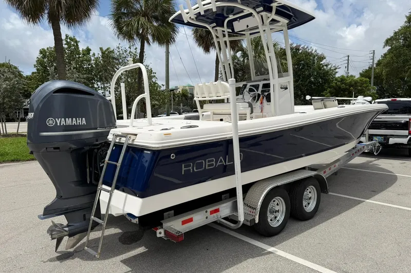 Slide: The Image of 2015 Robalo 246 Cayman boat on trailer with Yamaha engine, parked outdoors. - 3