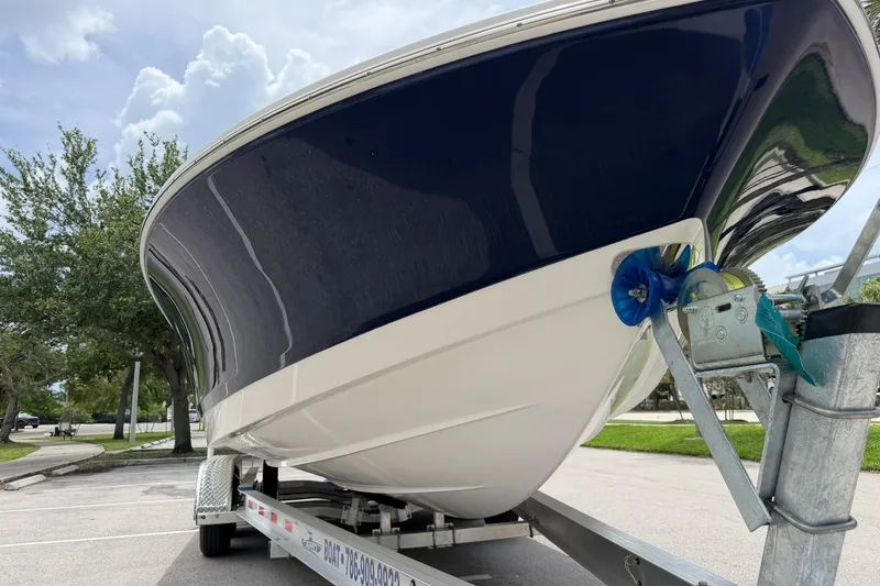 Slide: The Image of 2015 Robalo 246 Cayman boat on trailer, parked outdoors under cloudy sky. - 9