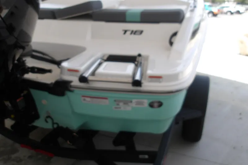 Slide: The Image of 2026 Tahoe T18 boat rear view with ladder and motor, displayed on a trailer. - 6