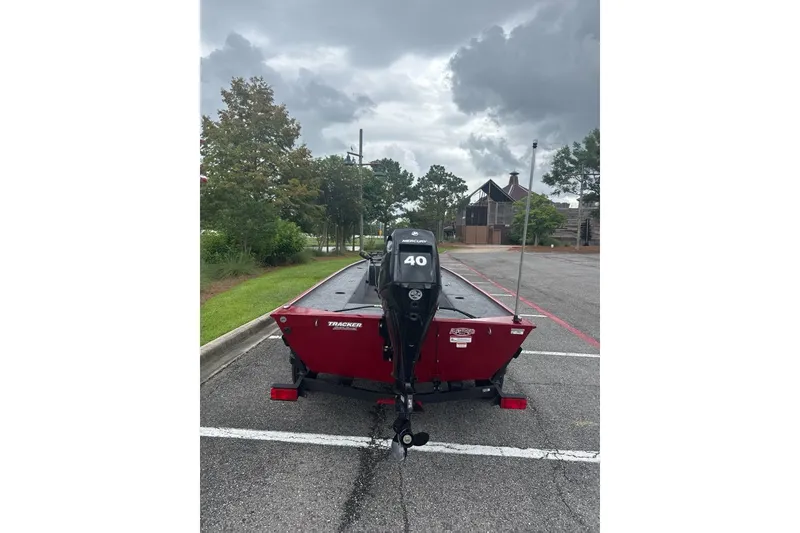 Slide: The Image of 2026 Tracker Panfish 17 boat with Mercury 40 engine in parking lot under cloudy sky. - 2