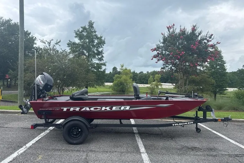 The Image of 2026 Tracker Panfish 17 boat on trailer in parking lot, cloudy sky background. - 0