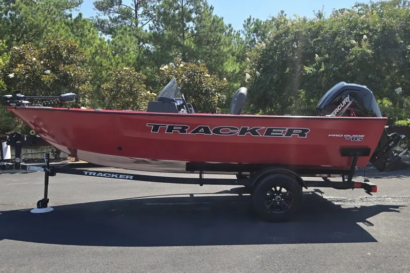 The Image of 2026 Tracker Pro Guide V-16 SC boat on trailer, red exterior, parked outdoors. - 0