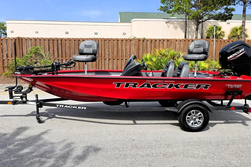 Slide: The Image of 2026 Tracker Pro Team 175 boat, red, on trailer, with Mercury engine, parked outdoors. - 9
