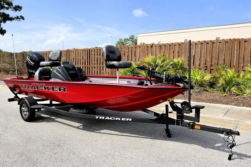 Slide: The Image of Red 2026 Tracker Pro Team 175 boat on trailer, parked outdoors near wooden fence. - 5
