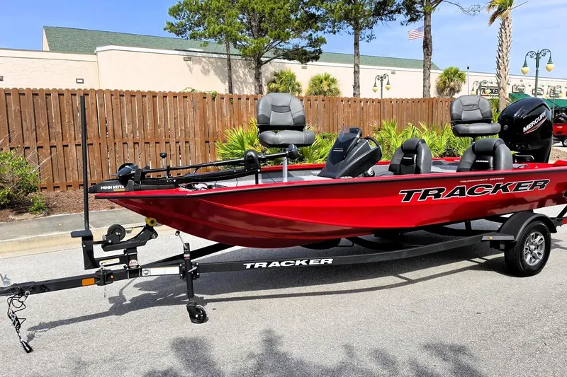 Slide: The Image of 2026 Tracker Pro Team 175 boat in vibrant red on a trailer, parked outdoors. - 11