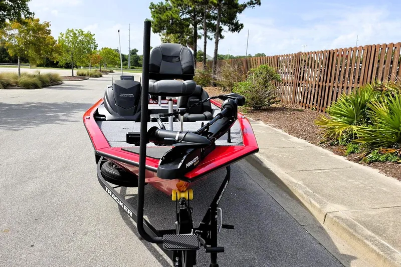 Slide: The Image of 2026 Tracker Pro Team 175 boat on trailer, parked near trees and fence. - 6