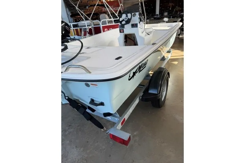 Slide: The Image of 2026 Mako Pro Skiff 17 CC boat on trailer, displayed indoors. - 1