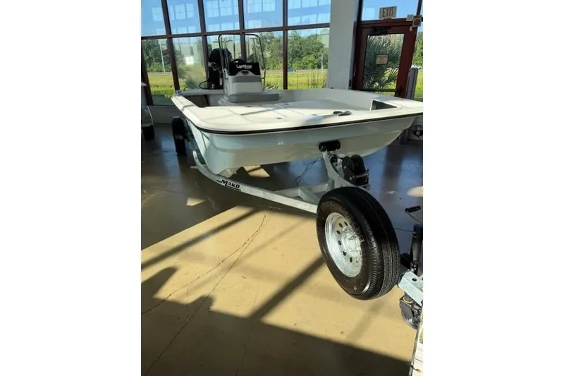 Slide: The Image of 2026 Mako Pro Skiff 17 CC boat displayed indoors on a trailer. - 3