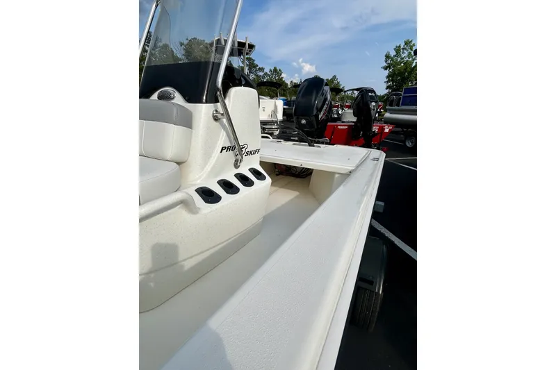 Slide: The Image of 2026 Mako Pro Skiff 13 CC boat, white interior, parked outdoors under blue sky. - 5