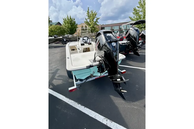 Slide: The Image of 2026 Mako Pro Skiff 13 CC boat with outboard motor in parking lot. - 1
