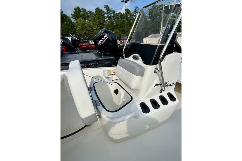 Slide: The Image of 2026 Mako Pro Skiff 13 CC boat interior with seating and console, featuring a Mercury engine. - 2