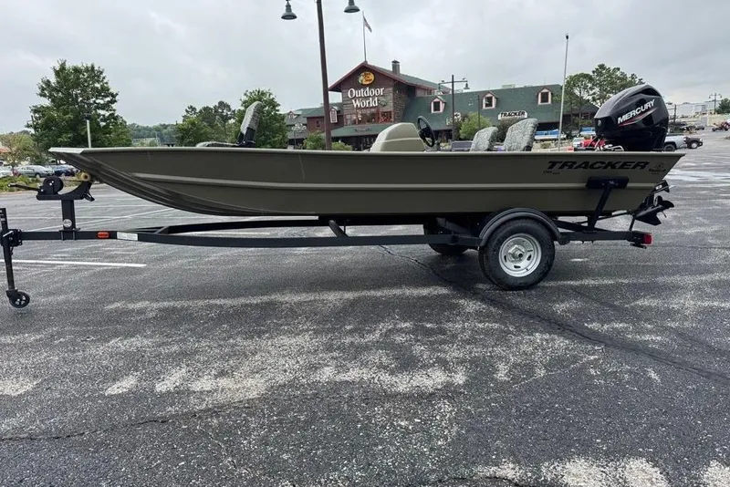 Slide: The Image of 2026 Tracker Grizzly 1754 SC boat on trailer in parking lot near outdoor store. - 38