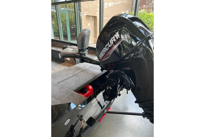 Slide: The Image of 2026 Tracker Super Guide V-16 T boat with Mercury outboard motor in showroom. - 2