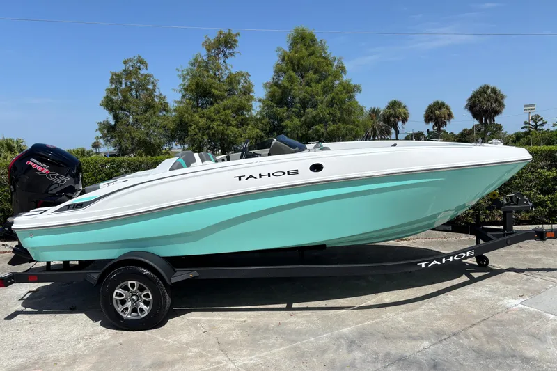 Slide: The Image of 2026 Tahoe T18 boat on trailer, turquoise and white design, parked outdoors. - 4