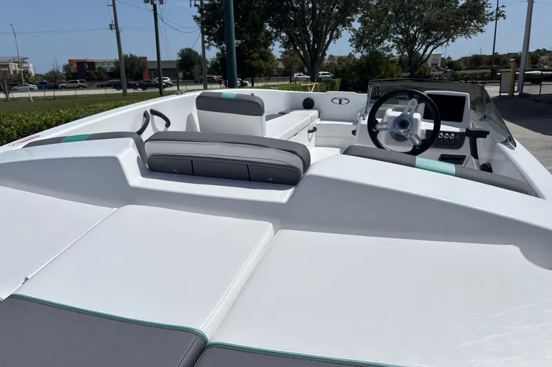 Slide: The Image of 2026 Tahoe T18 boat interior with modern dashboard and seating, parked outdoors. - 7