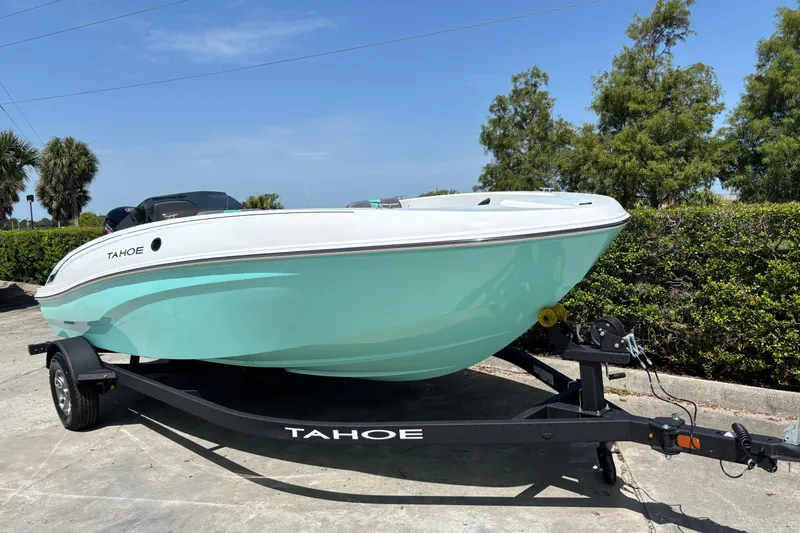 Slide: The Image of 2026 Tahoe T18 boat on trailer, mint green hull, parked outdoors. - 5