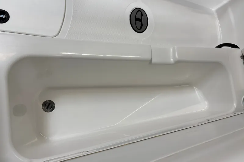 Slide: The Image of 2026 Tahoe T18 boat interior storage compartment with drain plug and latch. - 21