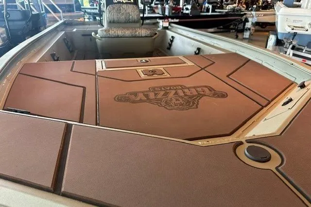 Slide: The Image of 2026 Tracker Grizzly 1860 CC boat interior with cushioned seating and storage compartments. - 6