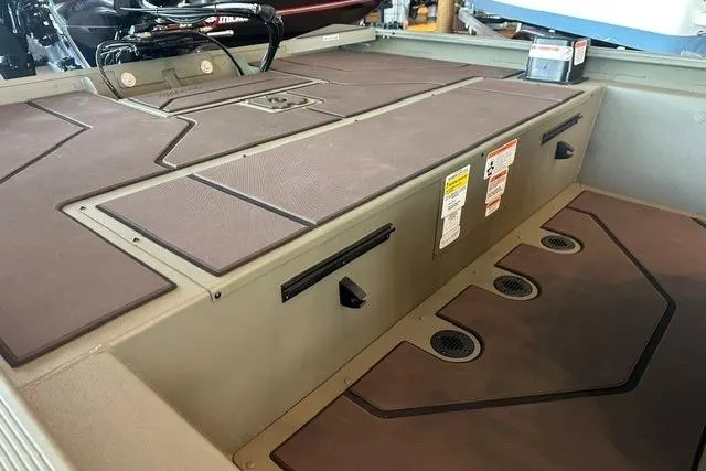 Slide: The Image of 2026 Tracker Grizzly 1860 CC boat interior with storage compartments and non-slip flooring. - 9