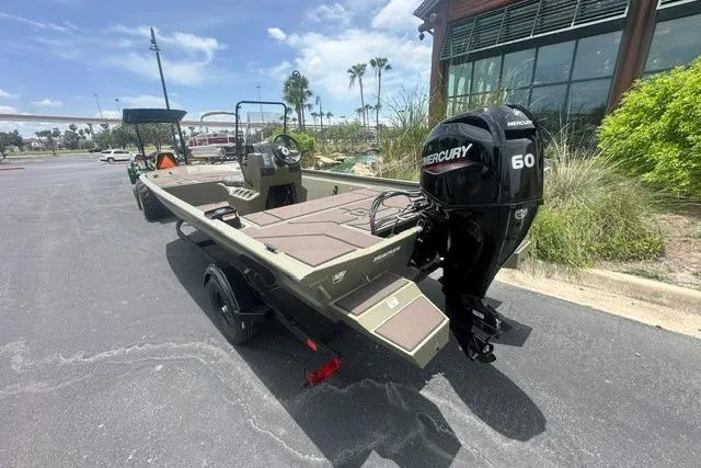 Slide: The Image of 2026 Tracker Grizzly 1860 CC boat with Mercury 60 engine, parked outdoors. - 2