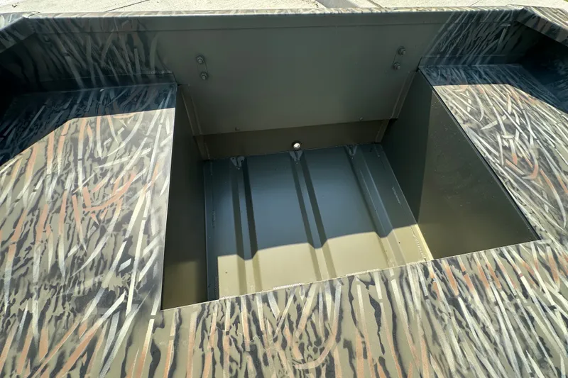 Slide: The Image of 2026 Tracker Grizzly 15 Jon boat interior with camouflage pattern and open storage compartment. - 23