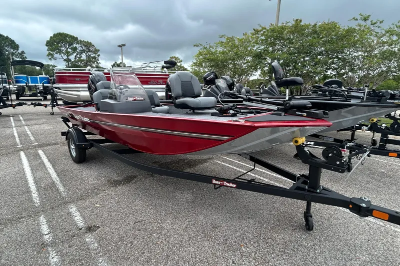 The Image of 2026 Tracker Bass Tracker Classic XL boat in a parking lot, featuring a sleek red design. - 0