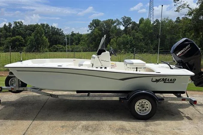Slide: The Image of 2026 Mako Pro Skiff 15 CC boat on trailer, outdoors with trees in background. - 6