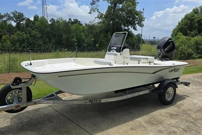 Slide: The Image of 2026 Mako Pro Skiff 15 CC boat on trailer, parked outdoors on a sunny day. - 7