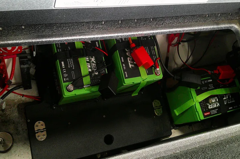 Slide: The Image of 2024 Nitro Z21 XL boat battery compartment with green lithium batteries and wiring. - 12