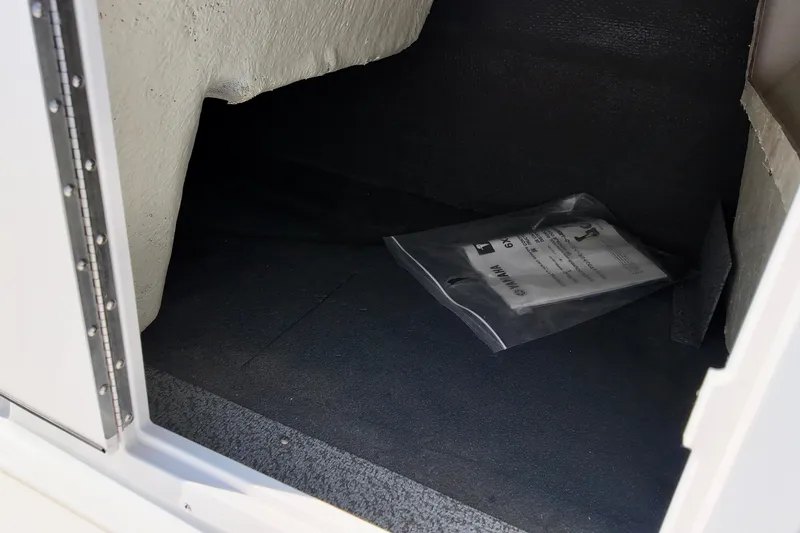 Slide: The Image of Storage compartment of 2026 Starcraft SVX 211 OB boat with manual inside. - 13