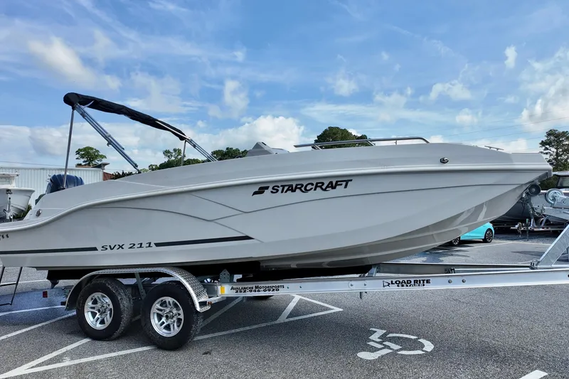 Slide: The Image of 2026 Starcraft SVX 211 OB boat on trailer under blue sky. - 2