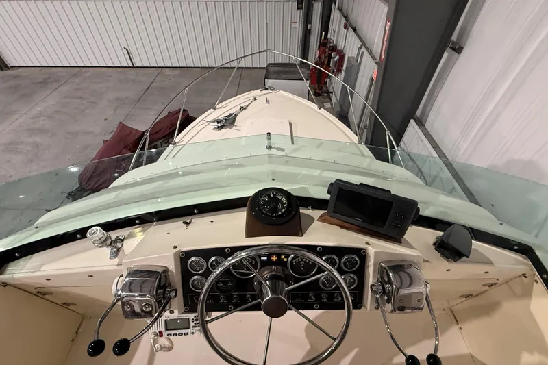 Slide: The Image of 1973 Bertram 28 Flybridge Cruiser cockpit with steering wheel, compass, and navigation equipment. - 6