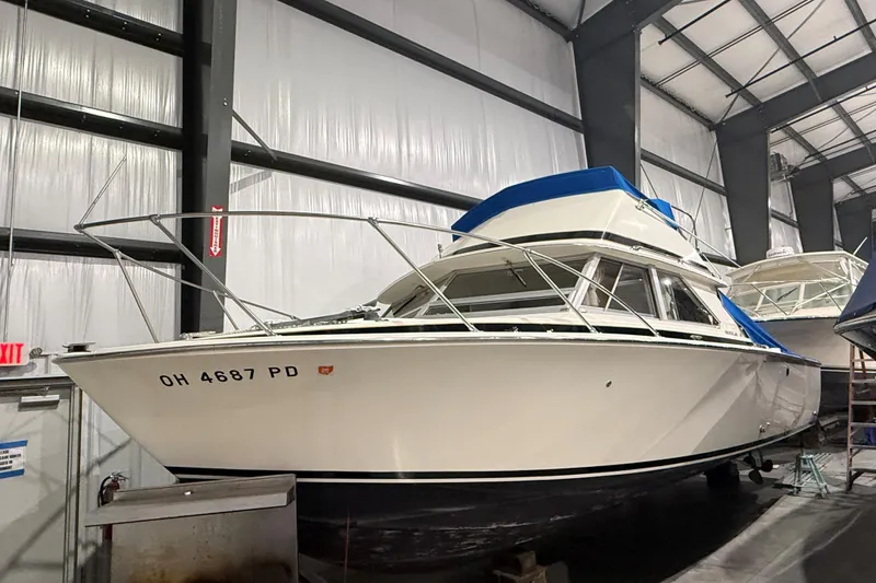 Slide: The Image of 1973 Bertram 28 Flybridge Cruiser in indoor storage, showcasing classic design. - 16